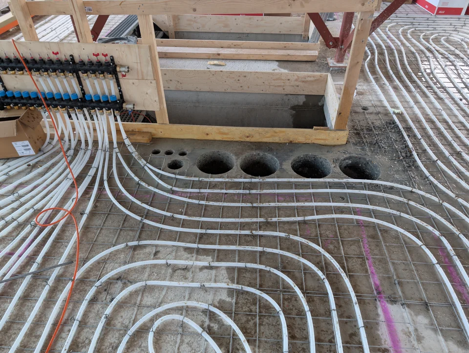 Meerdere ronde boringen in een betonvloer voor technische doorvoeren.