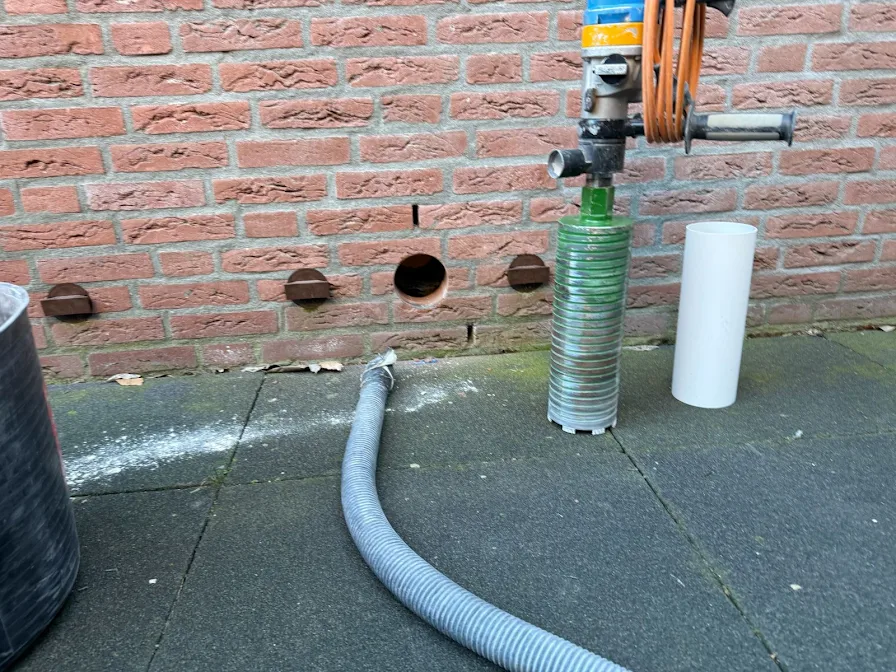 Kruipruimteventilatiegaten boren langs een gevel in Utrecht