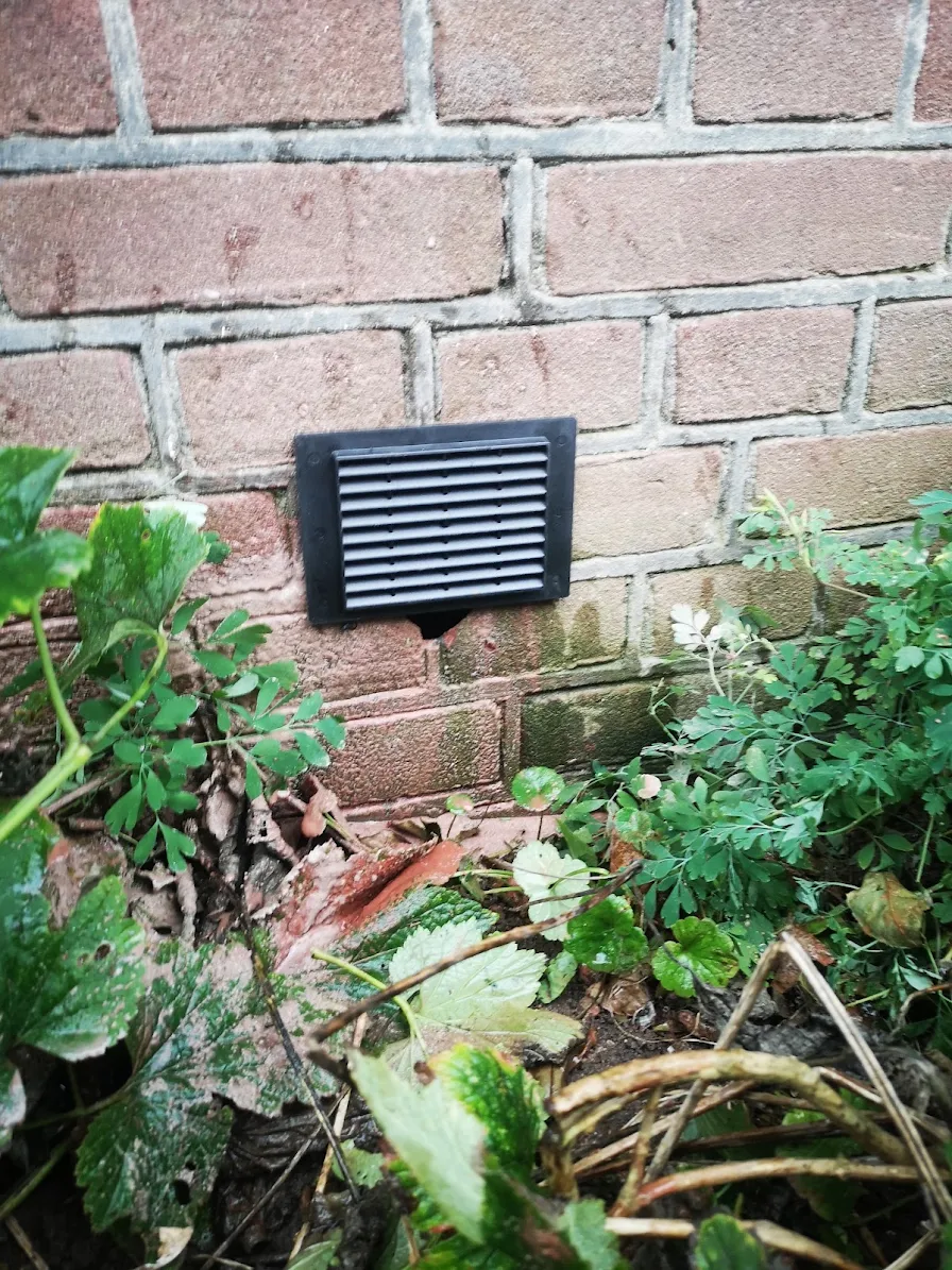 Afgewerkt zwart ventilatierooster op de gevel