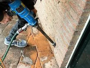 Drillpro aan het werk bij het aanbrengen van kruipruimteventilatie; illustratie van de werkwijze.
