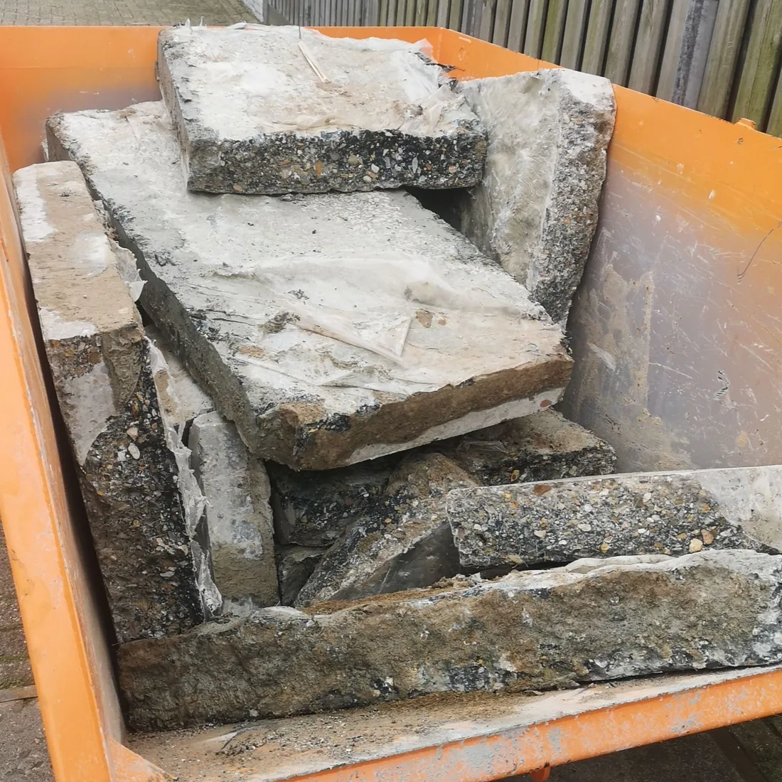 Uitgebroken beton verzameld voor afvoer tijdens het garageproject.