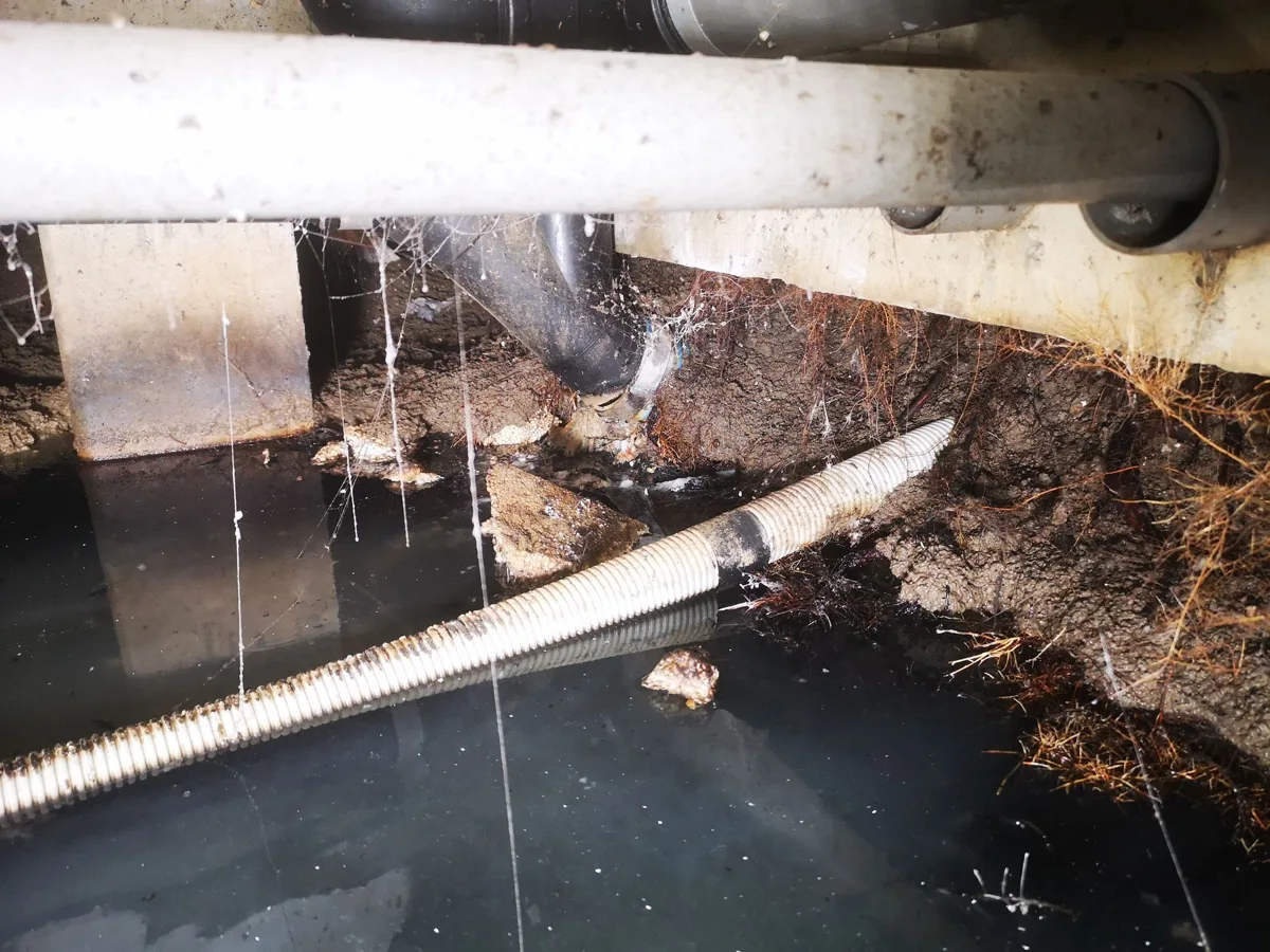 Water onder leidingen in een kruipruimte