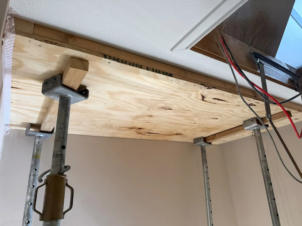 Houten paneel en stempels aan de onderzijde van de werkzone