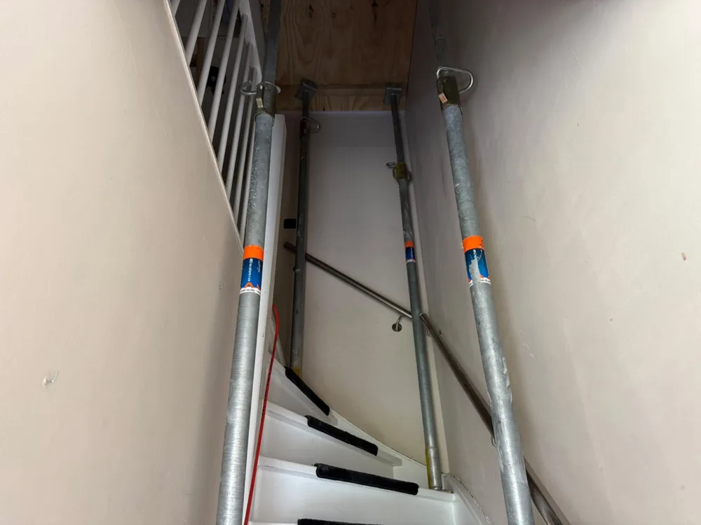 Stempels in het bestaande trappenhuis tijdens voorbereiding van de vloeropening